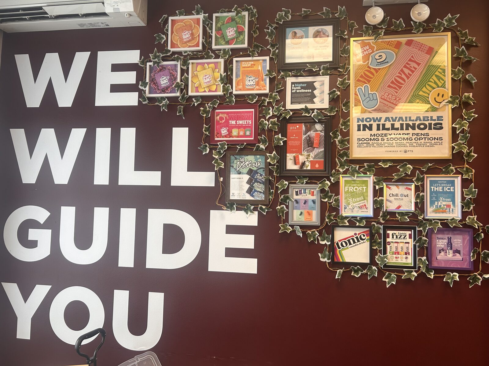 A “We Will Guide You” cannabis product education display wall