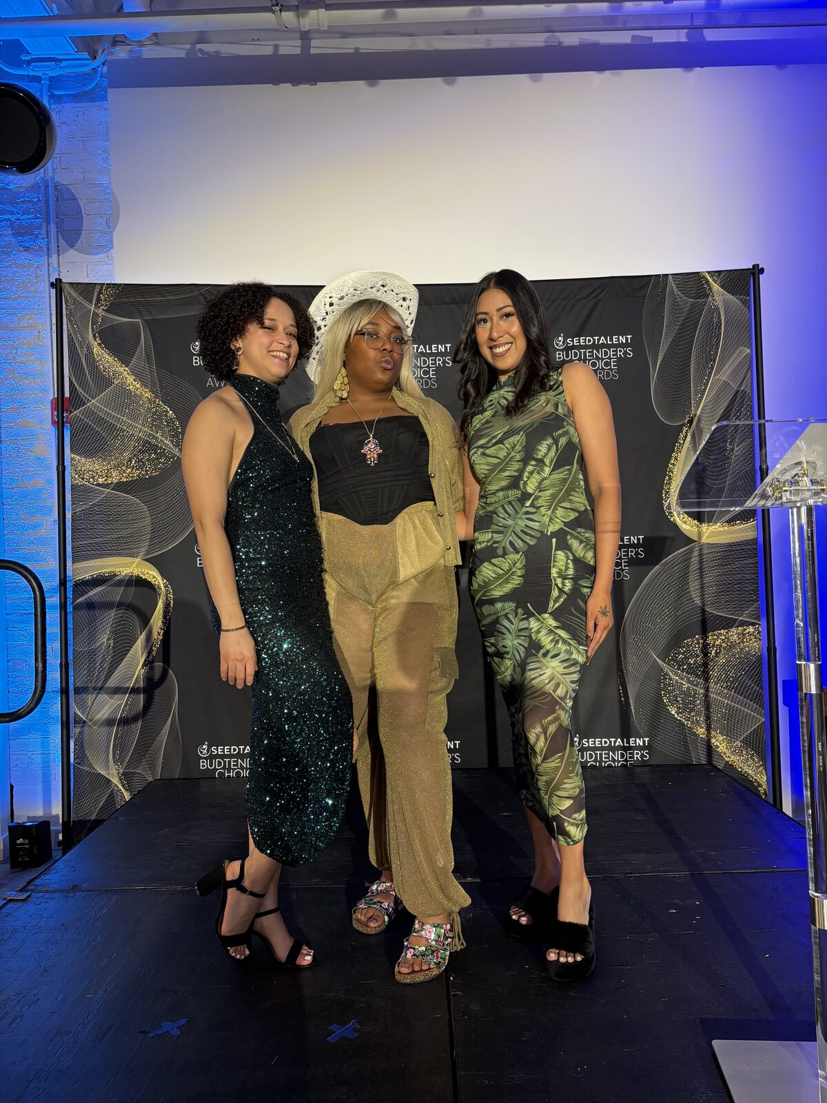 Three women dressed up and hosting a cannabis industry event