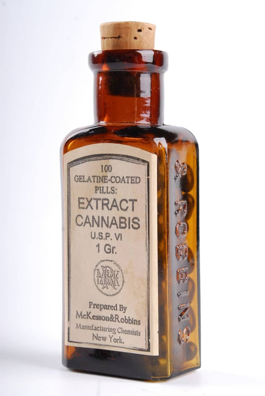A vintage amber glass bottle labeled 100 Gelatine-Coated Pills: Extract Cannabis, prepared by McKesson & Robbins Manufacturing Chemists, New York